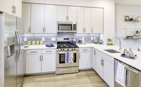 a modern kitchen with white cabinets and stainless steel appliances